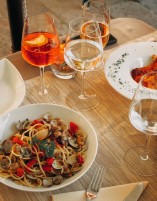 A plate of spaghetti and glasses of wine on the table